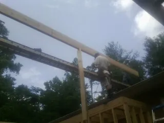 Carpenter setting a ridge beam over a new addition frame — Ice Dam Removal by Roofing Brothers in Munfordville