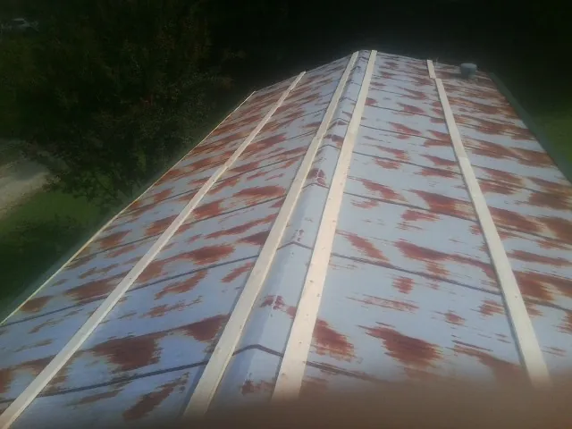 Rusted metal roof panels with new wood purlins before replacement — Storm Damage Roof Repair in Munfordville by Roofing Brothers