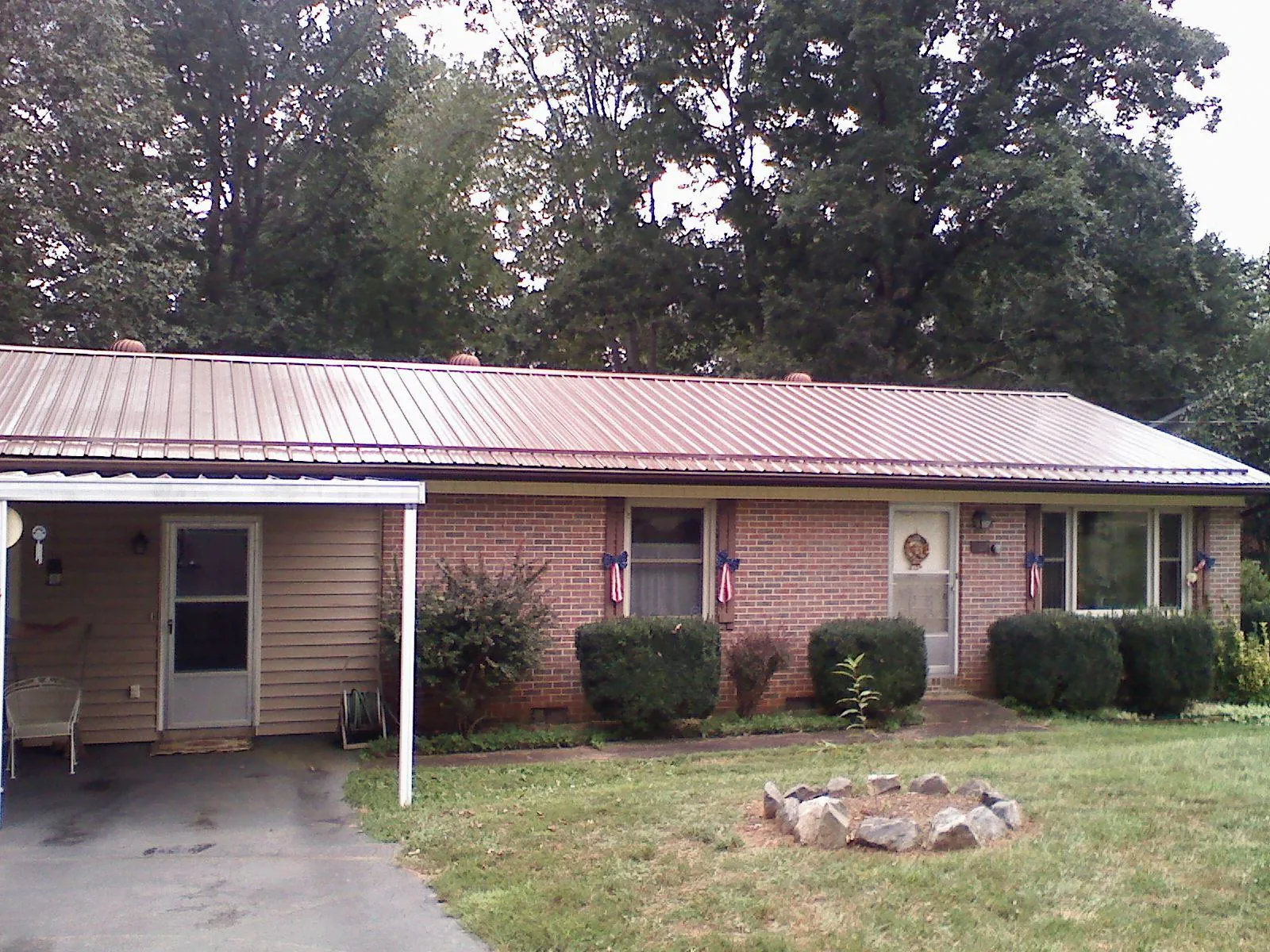 Bronze metal roof and carport on a brick ranch home — Roof Repair work by our crew in Munfordville